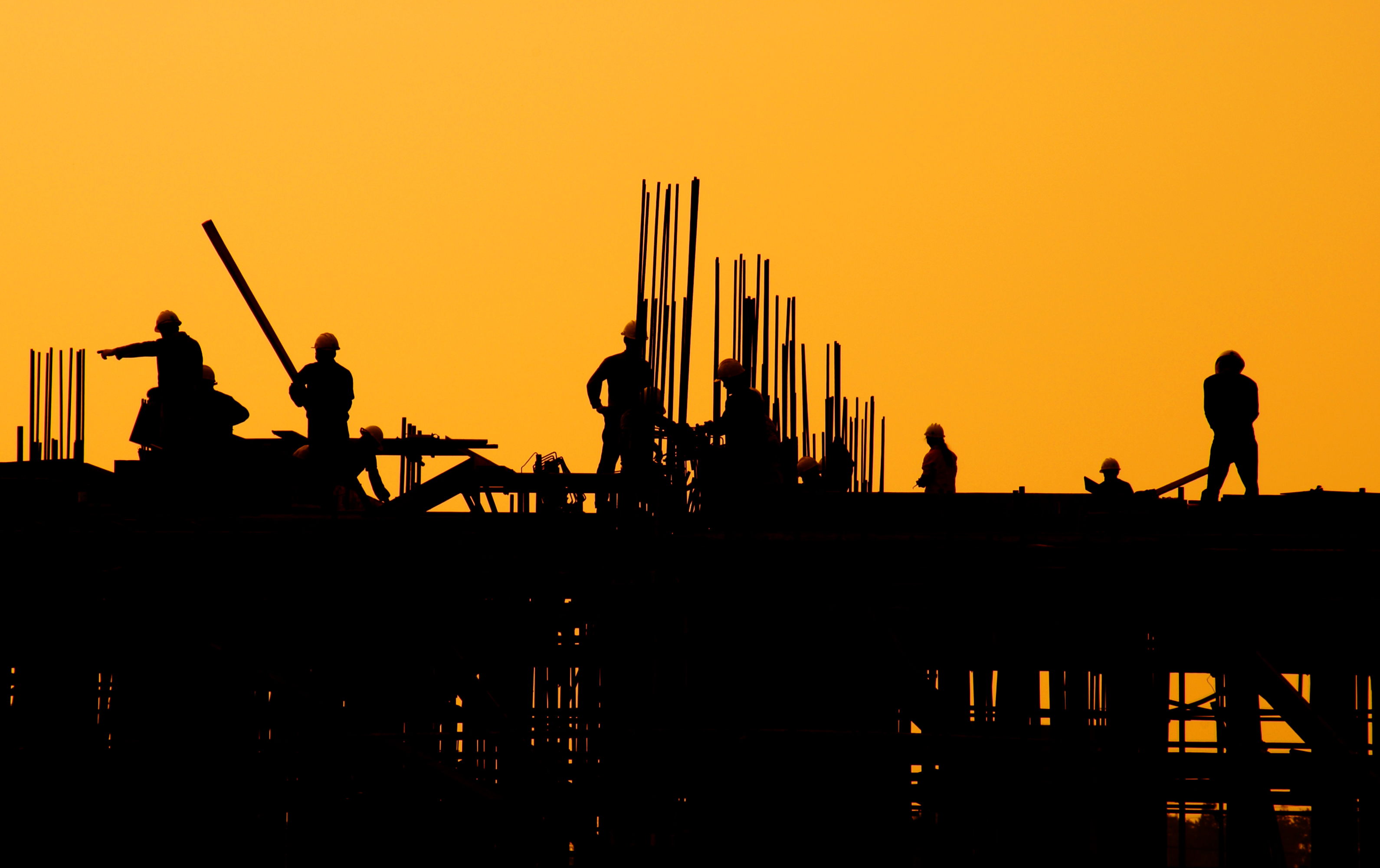 Construction workers at sunset